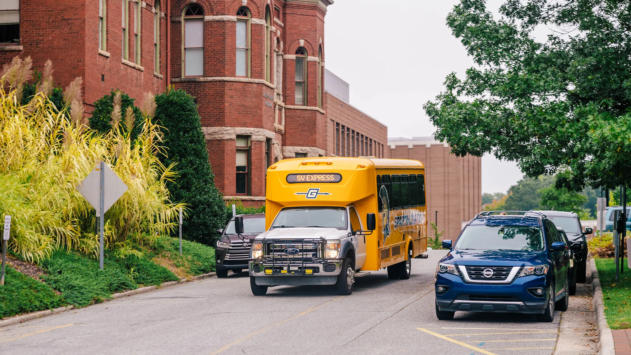 A Spartan Village Express Spartan Chariot passing by the Foust Building.